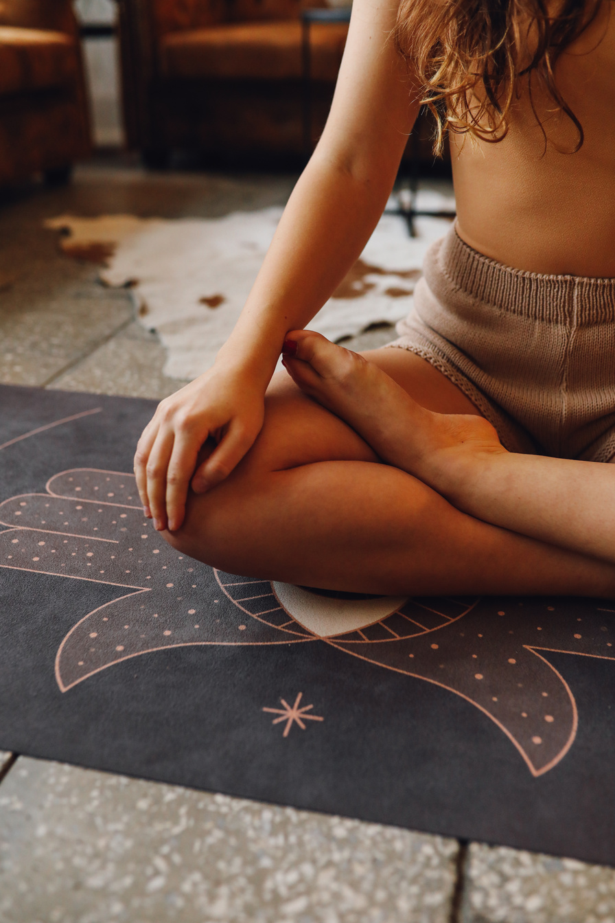 Photo of a Woman Meditating on a Black Yoga Mat